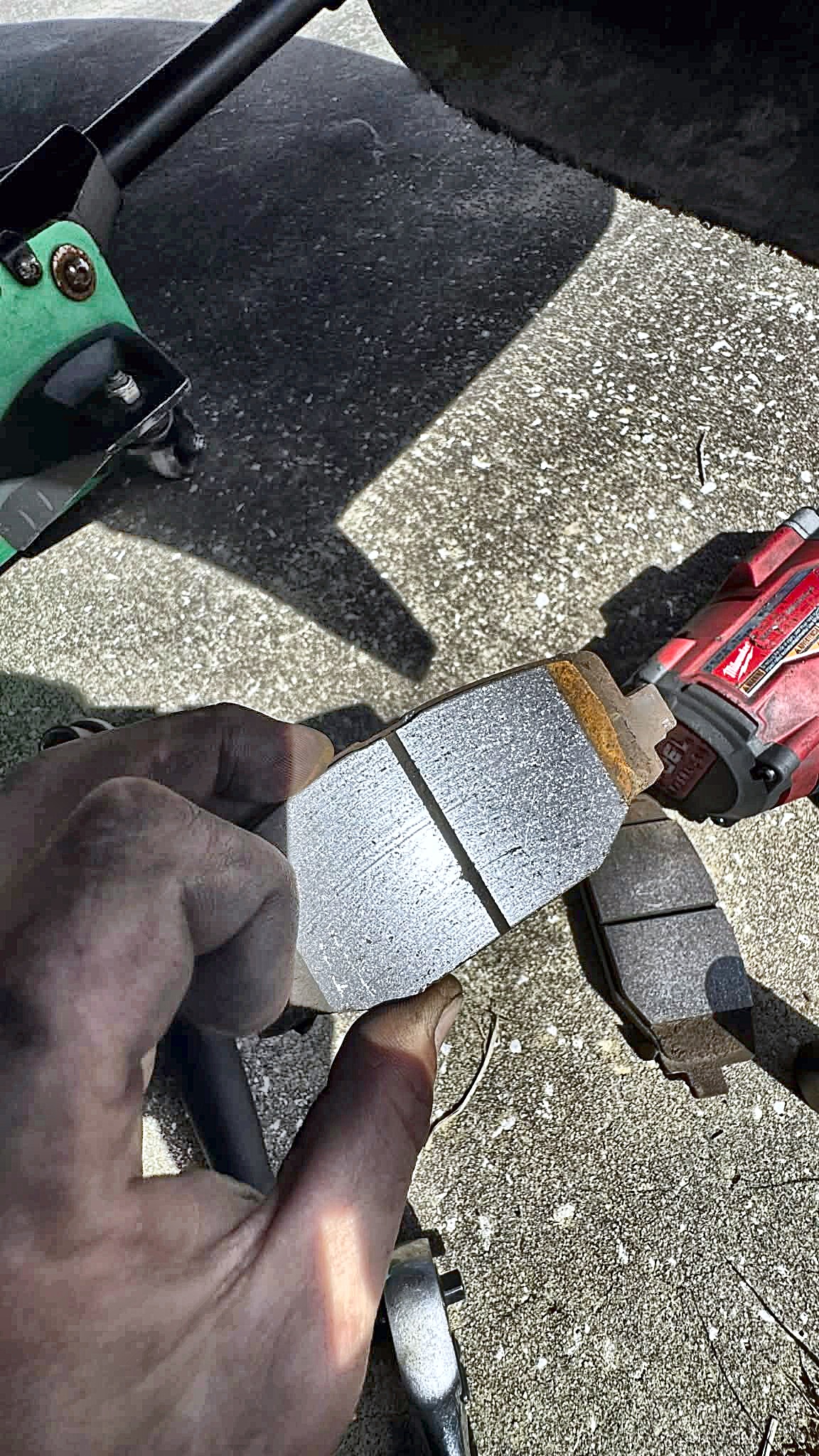 Worn brake pad next to a new one